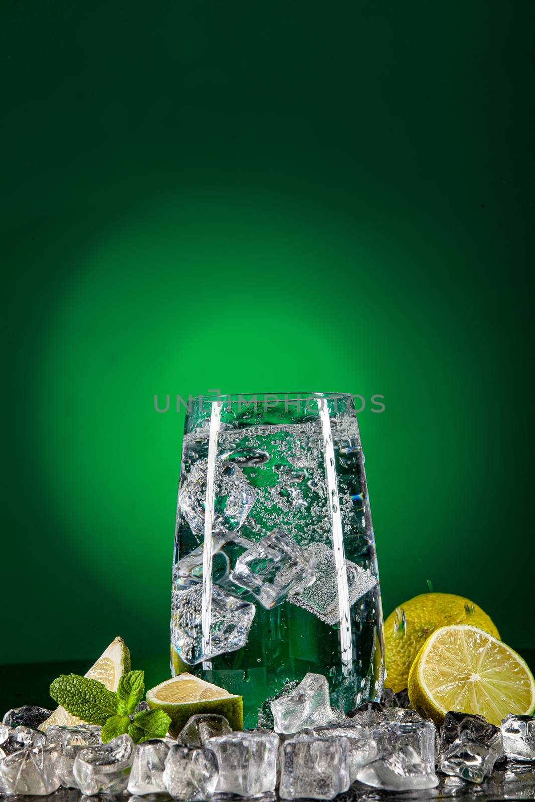Glass of water, crystals of ice and lime