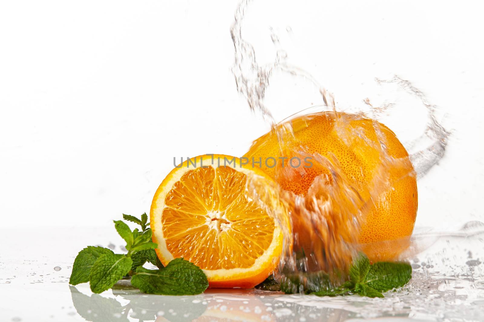 Grapefruit, orange and mint on a glass background