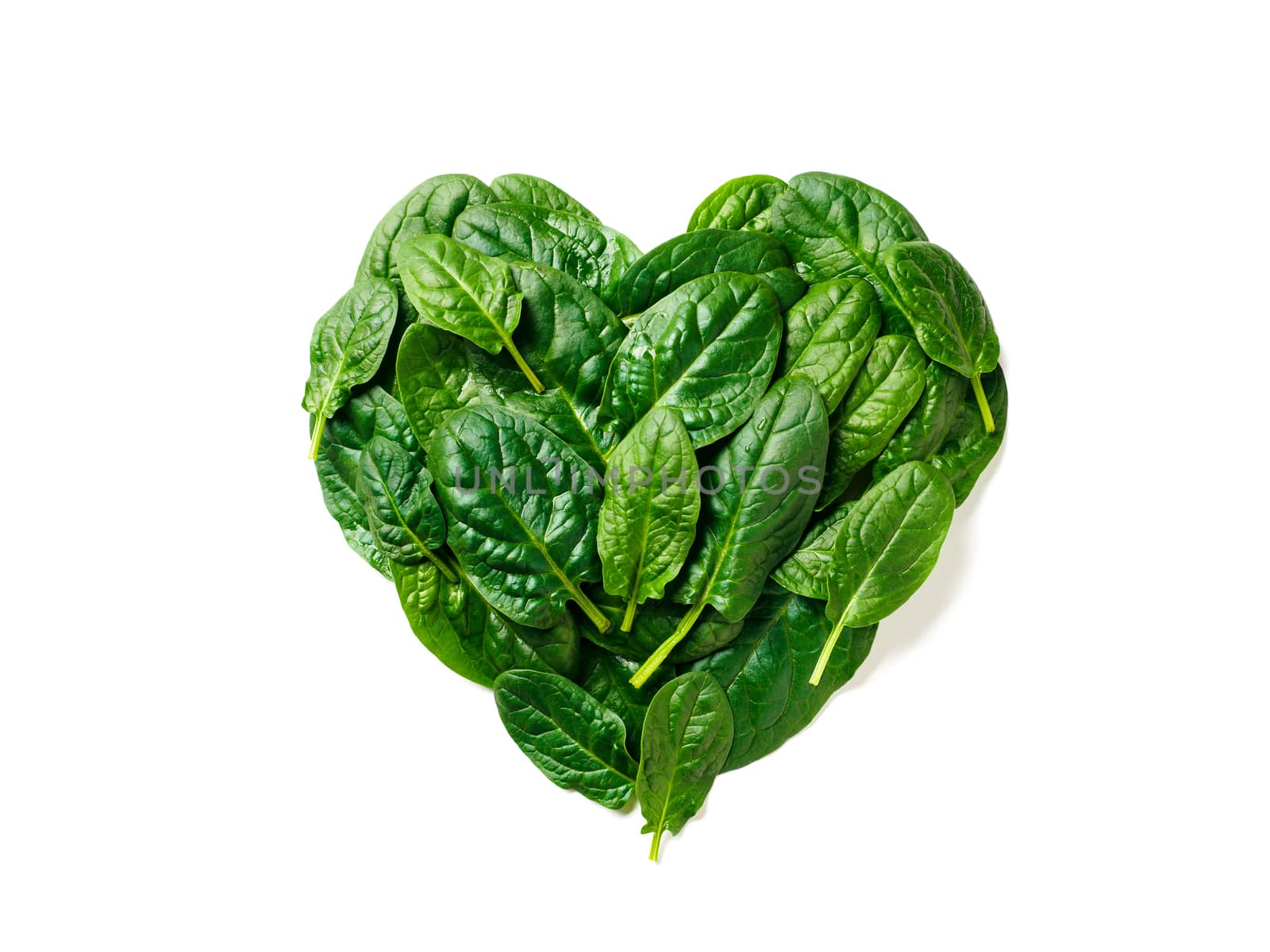 Heart shape made from spinach leaves. Spinach pattern isolated on white with clipping path. Creative layout from perfect fresh baby spinach leaves - heart health, vegan, low carb or keto diet concept