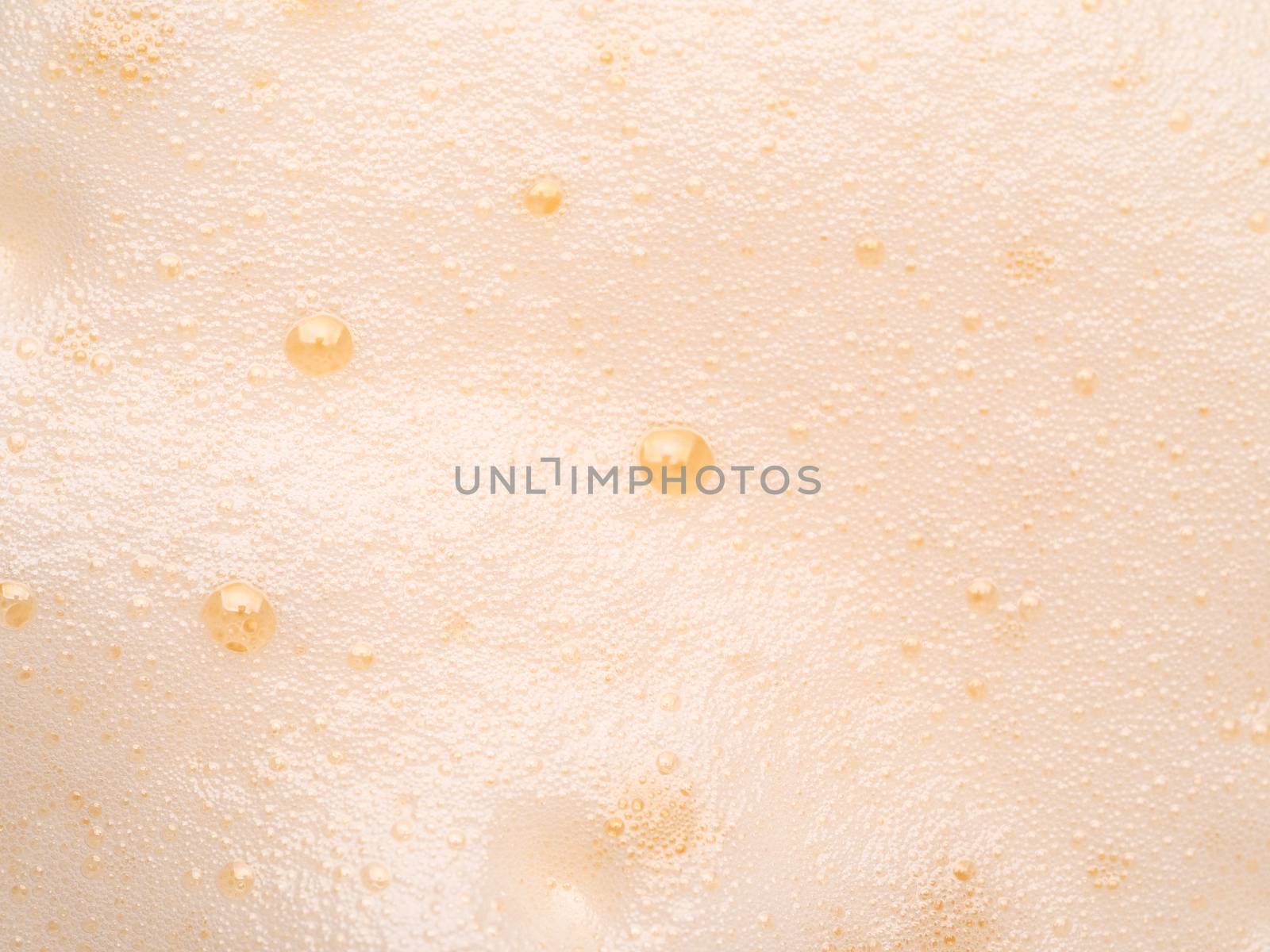 Foam texture extreme close up as background. Milkshake or cappucino foam with bubbles macro shoot. Copy space for text.