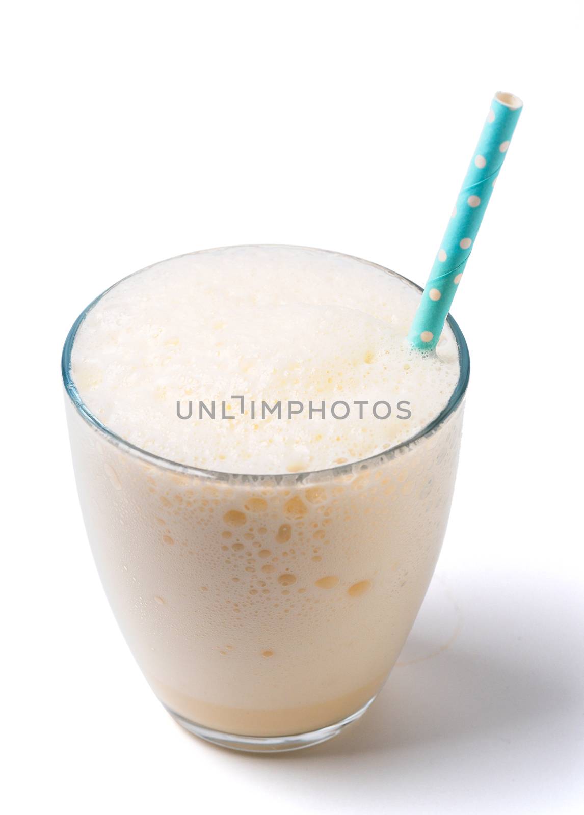 Vanilla milkshake with foam isolated on white. Delicious milk dessert with vanilla in glass isolated on white with clipping path.