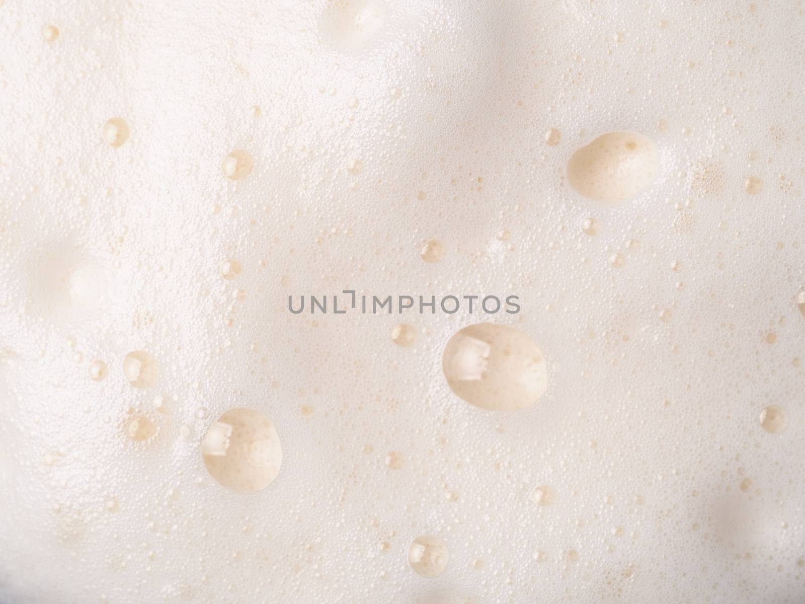 Foam texture extreme close up as background. Beer or cappucino foam with bubbles macro shoot. Copy space for text.