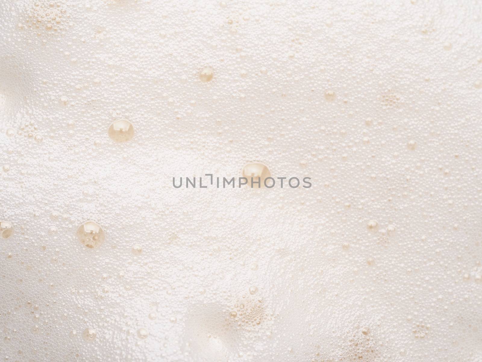 Foam texture extreme close up as background. Beer or cappucino foam with bubbles macro shoot. Copy space for text.