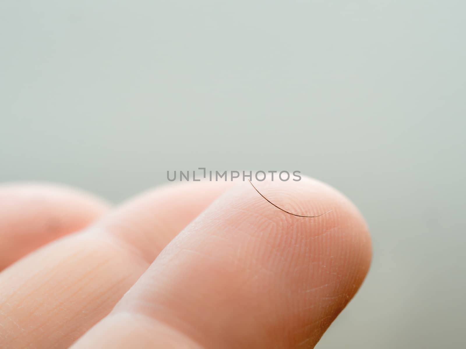 Loss of eyelashes concept. Eyelash on phalanx close up. One dropped eyelash on finger macro shoot. Eyelash loss problem. Copy space for text.