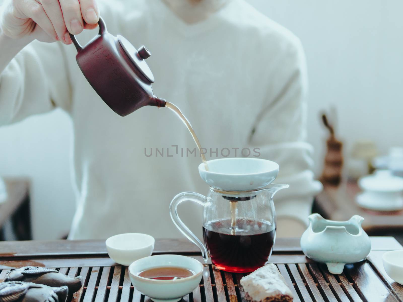 Chinese tea ceremony. Master pouring puer tea in glass teapot. Pu erh tea ceremony.