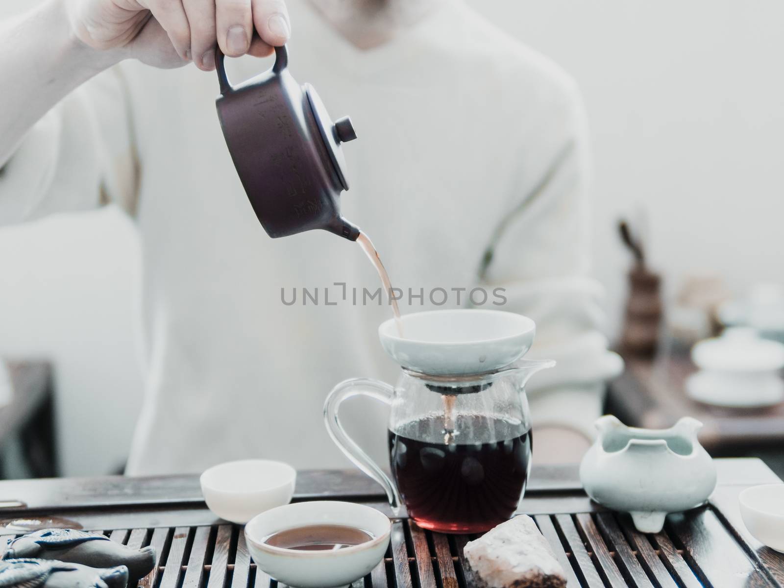 Chinese tea ceremony. Master pouring puer tea in glass teapot. Pu erh tea ceremony.