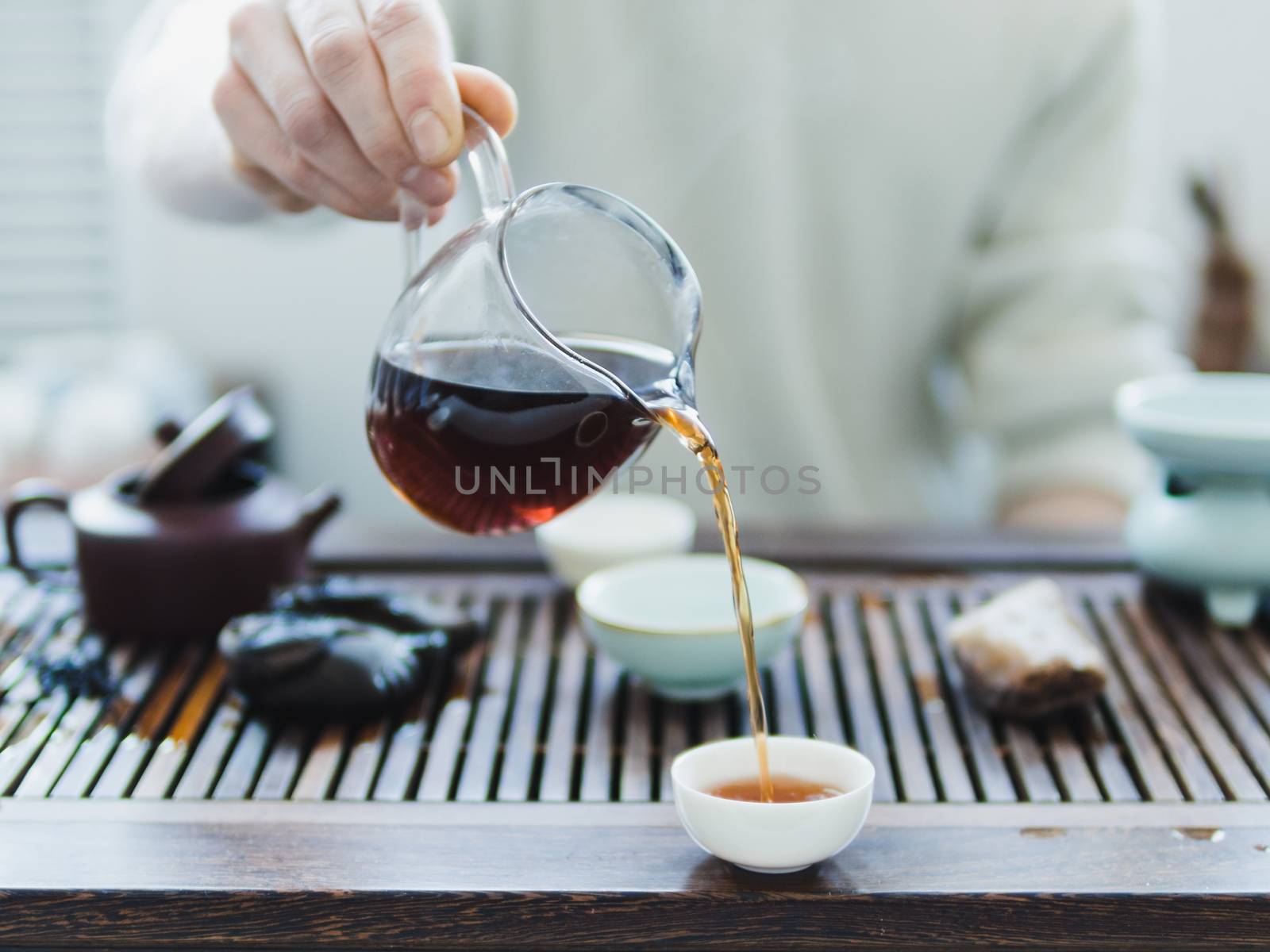 Chinese tea ceremony. Master pouring puer tea in cups. Pu erh tea ceremony.