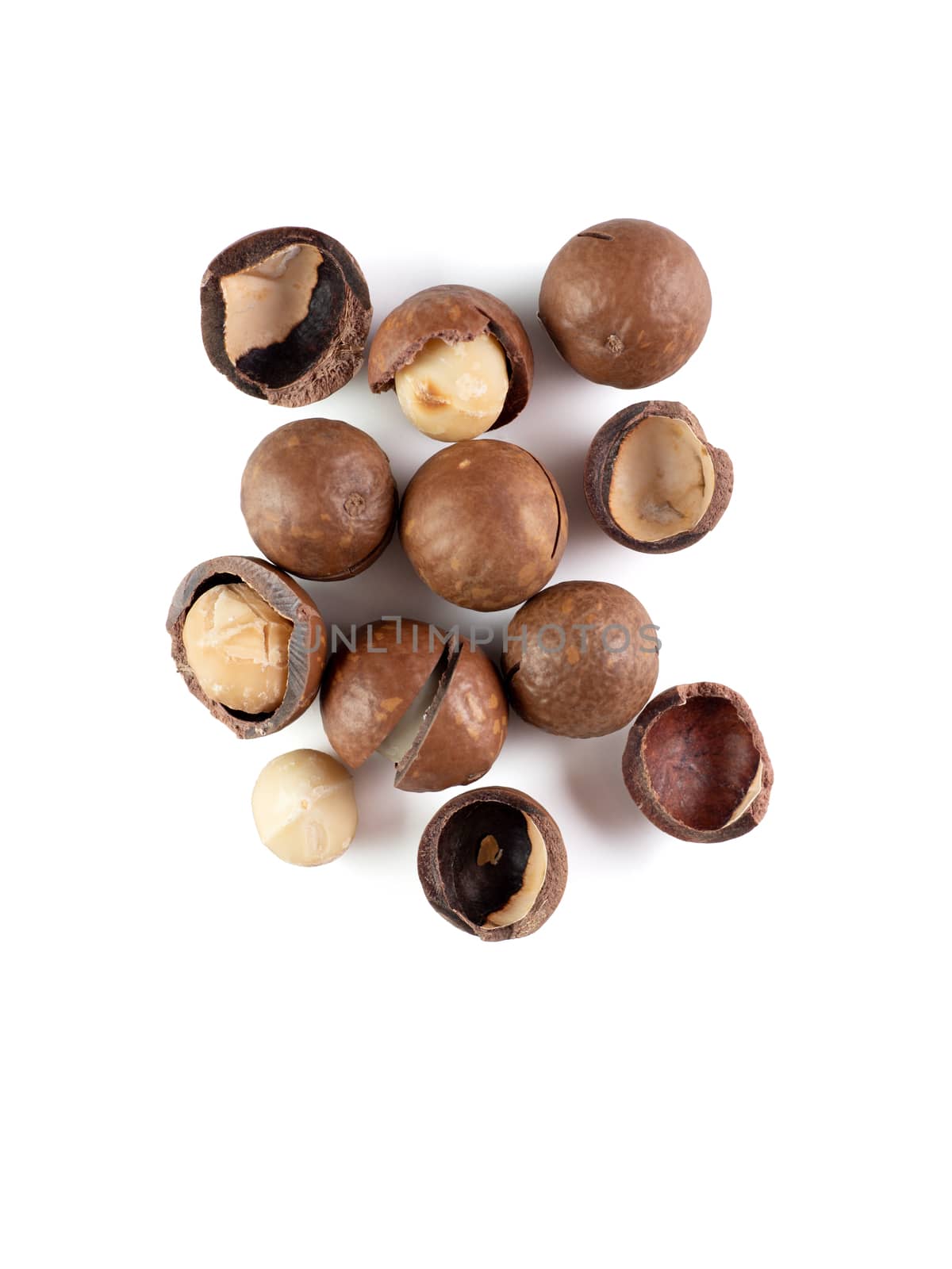 Heap of macadamia nuts on white background with clipping path.. Set of peeled and unpeeled macadamia nuts isolated on white, top view or flat lay. Vertical. Copy space for text.