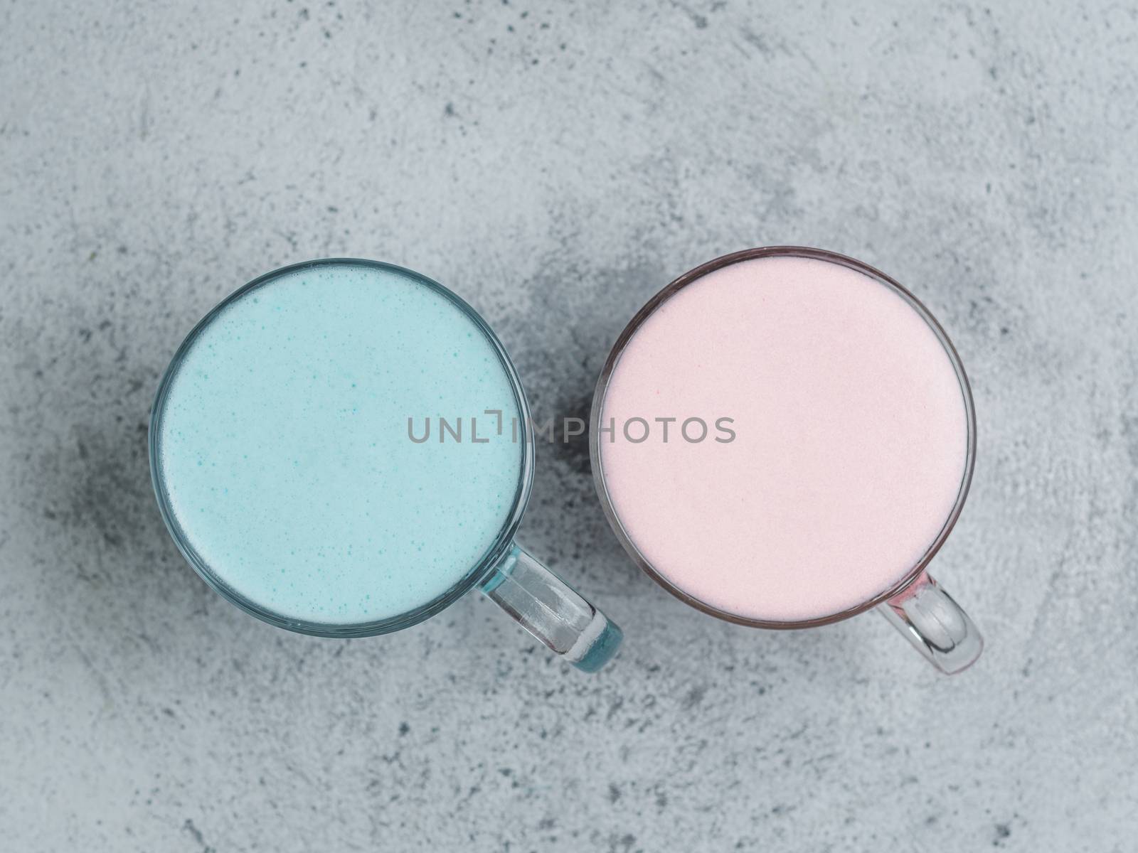 Trendy drink: Blue and pink latte. Hot butterfly pea latte or blue spirulina latte and pink beetroot or raspberry latte on gray cement textured background. Copy space for text. Top view or flat lay.