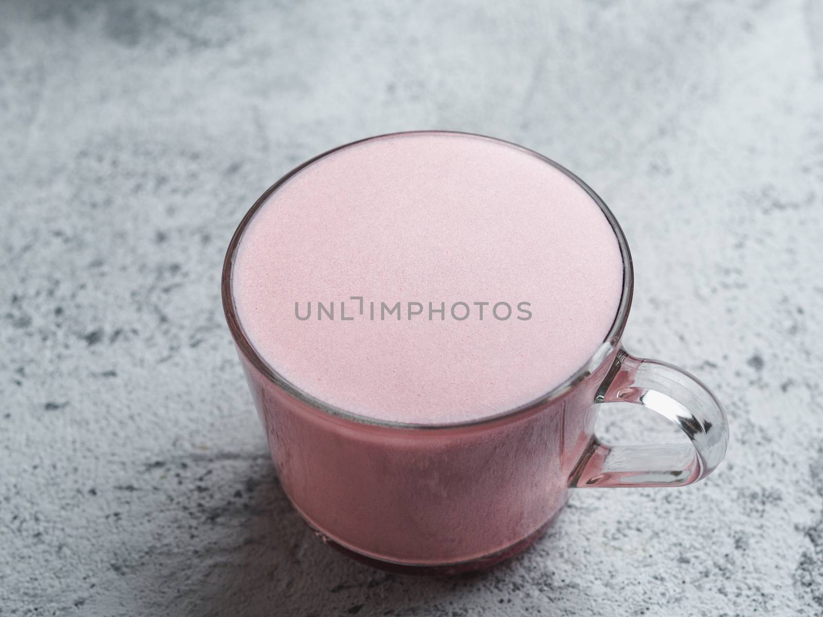 Trendy drink: pink latte. Beetroot or raspberry latte on gray cement background.