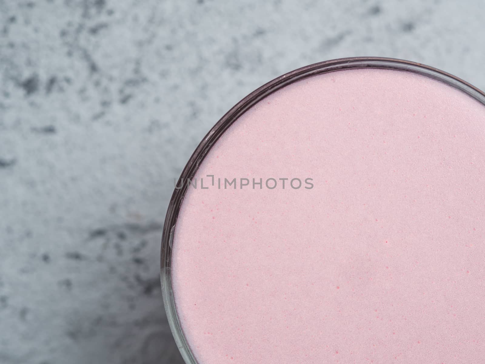 Trendy drink: pink latte. Close up view of hot beetroot or raspberry latte on gray cement background. Copy space for text. Top view or flat lay.