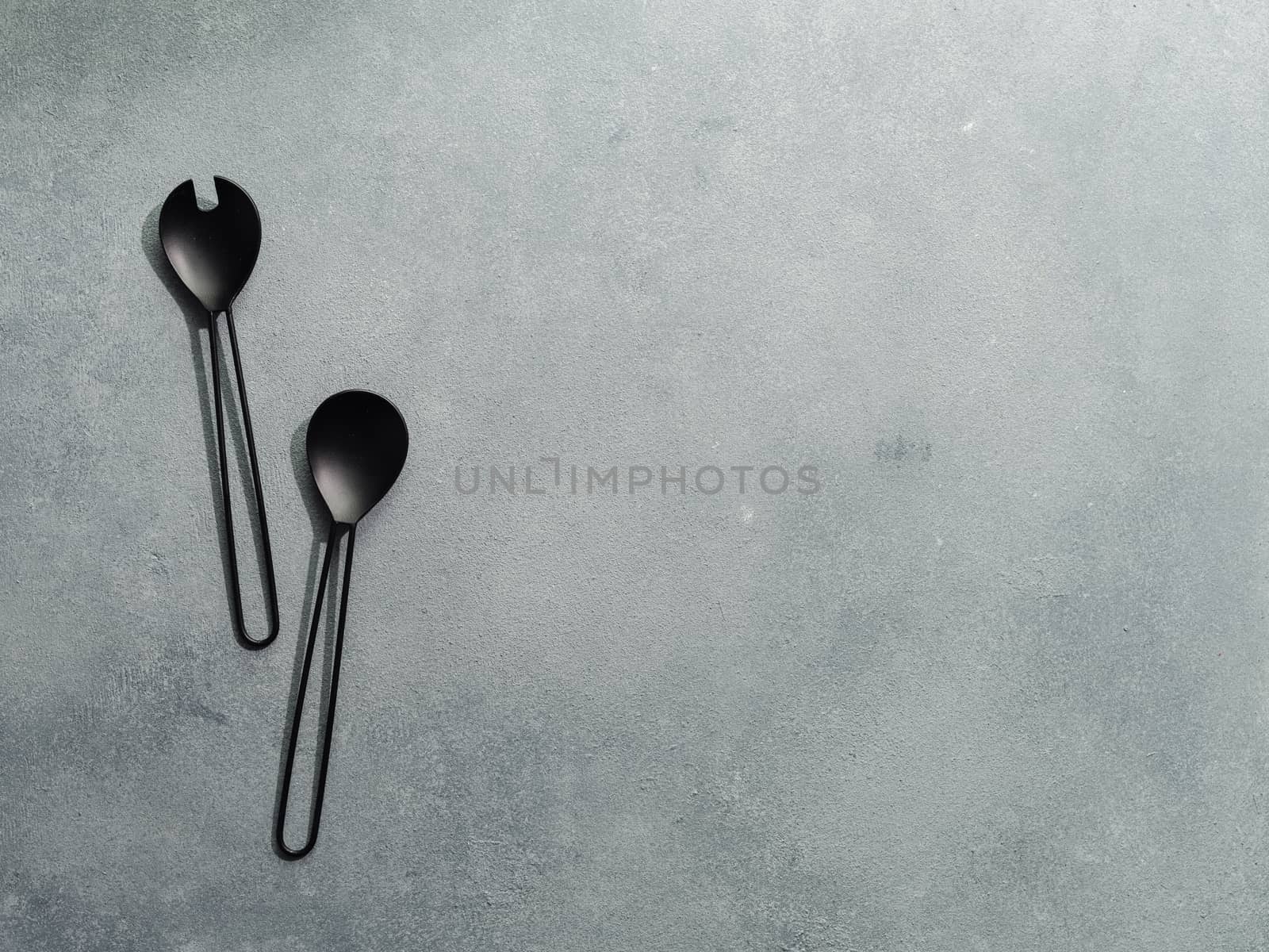 Salad serving utensils on gray stone,copy space by fascinadora