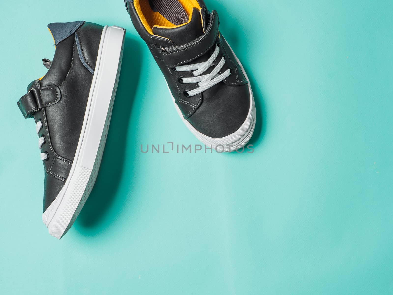 Gray and yellow sneakers on blue background by fascinadora