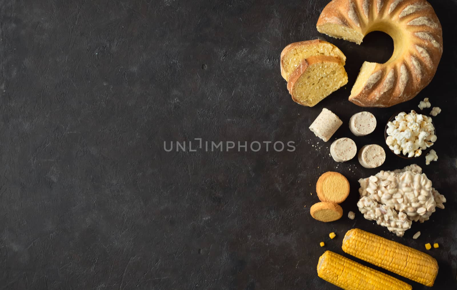 Festa Junina traditional food background,copy space for text. Delicious sweets for Brazilian Festa Junina Party: cornmeal cake Bolo de Fuba, corn cookies,popcorn,peanut candy Pacoca, corn ear top view