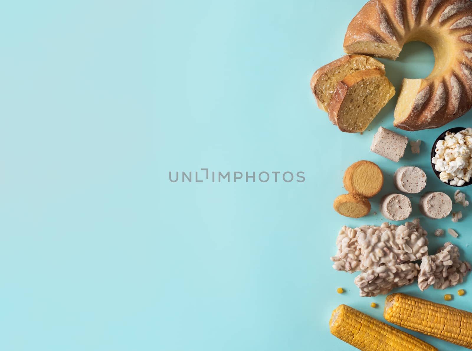Festa Junina traditional food background,copy space for text. Delicious sweets for Brazilian Festa Junina Party: cornmeal cake Bolo de Fuba, corn cookies,popcorn,peanut candy Pacoca, corn ear top view