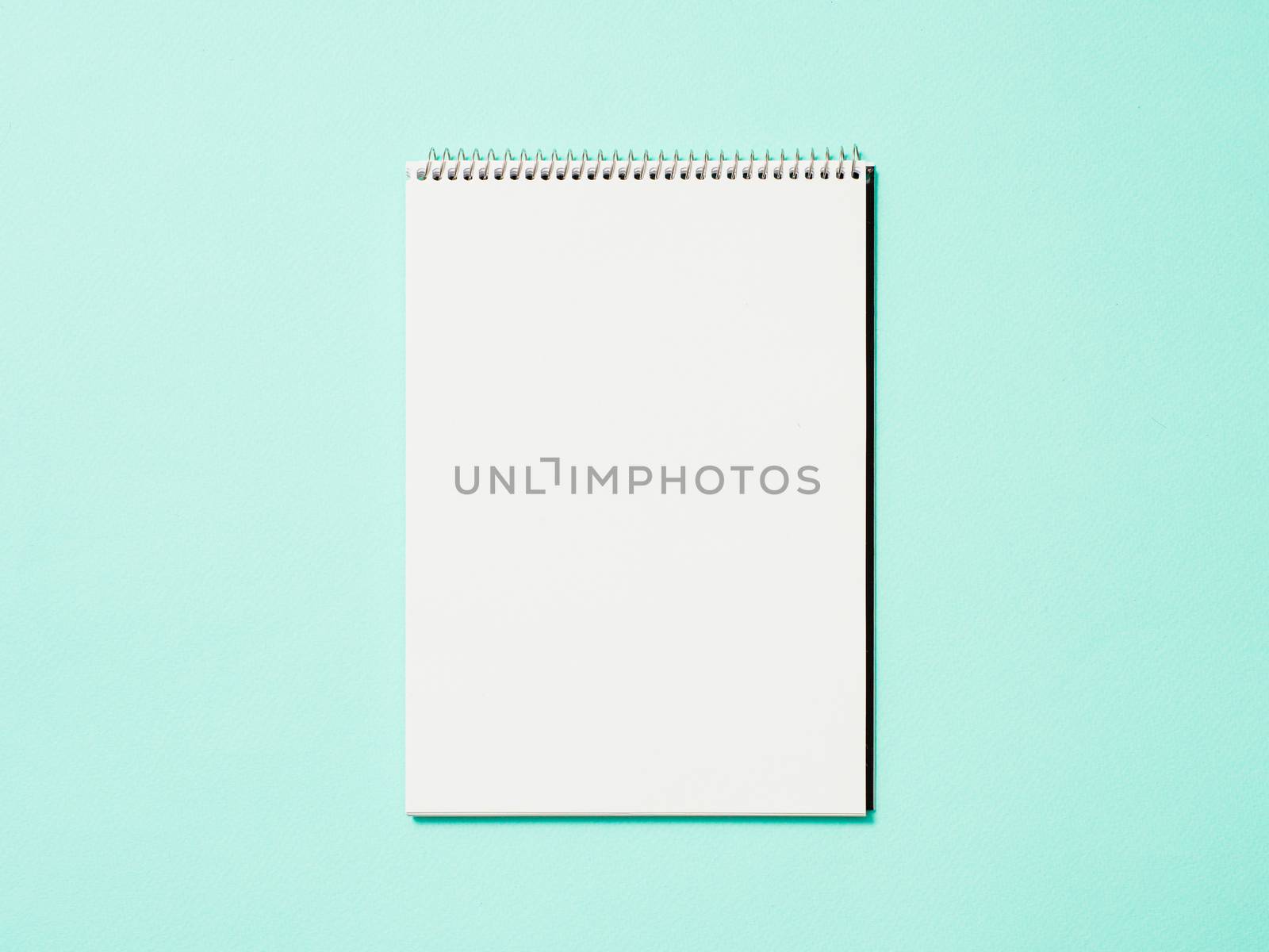 Paper notebook. Empty paper sketchbook on blue background. Top view or flat lay. Copy space for text or design.