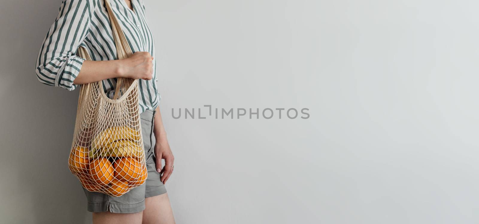 woman standing with mesh bag on shoulder by fascinadora