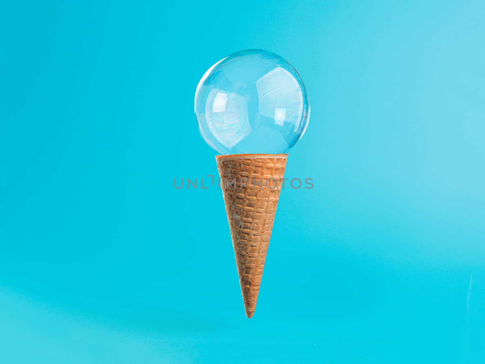 Ice cream cone with soap bubble. Creative layout ice cream in air over blue background. Soap bubble ice cream on brigt blue background. Semi flat style. Minimal summer concept