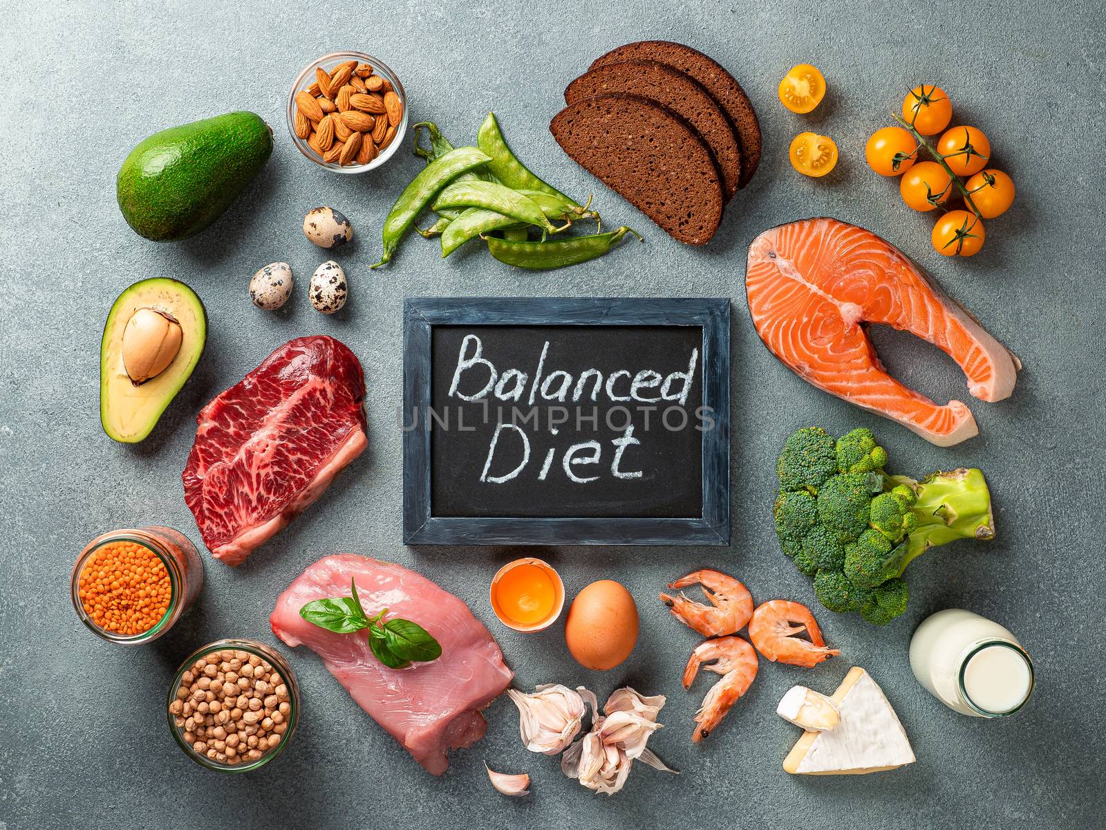 Balanced diet - healthy food on gray stone background. Various food ingredients and chalkboard with words Balanced Diet. Top view or flat lay.