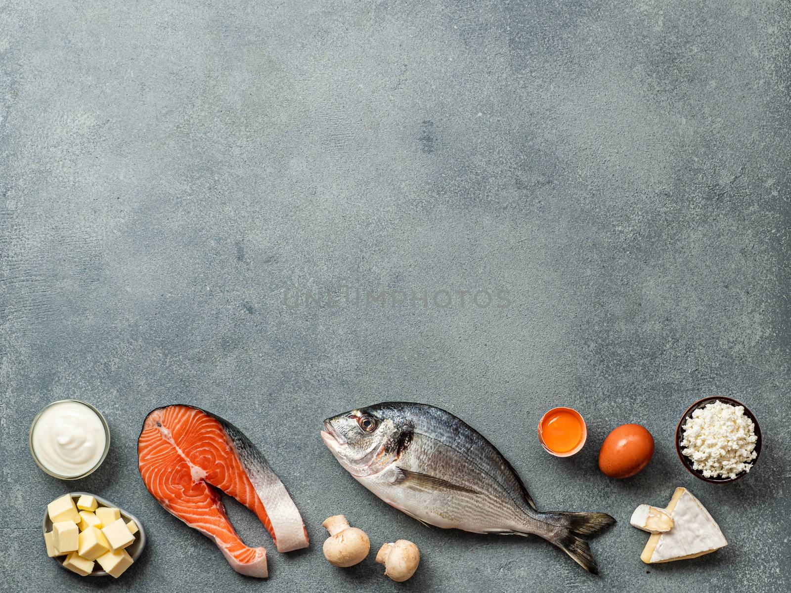 Vaitamin D sources concept with copy space for text. Fish, salmon, dairy products, eggs, mushrooms on gray stone background. Top view or flat lay. Copy space top