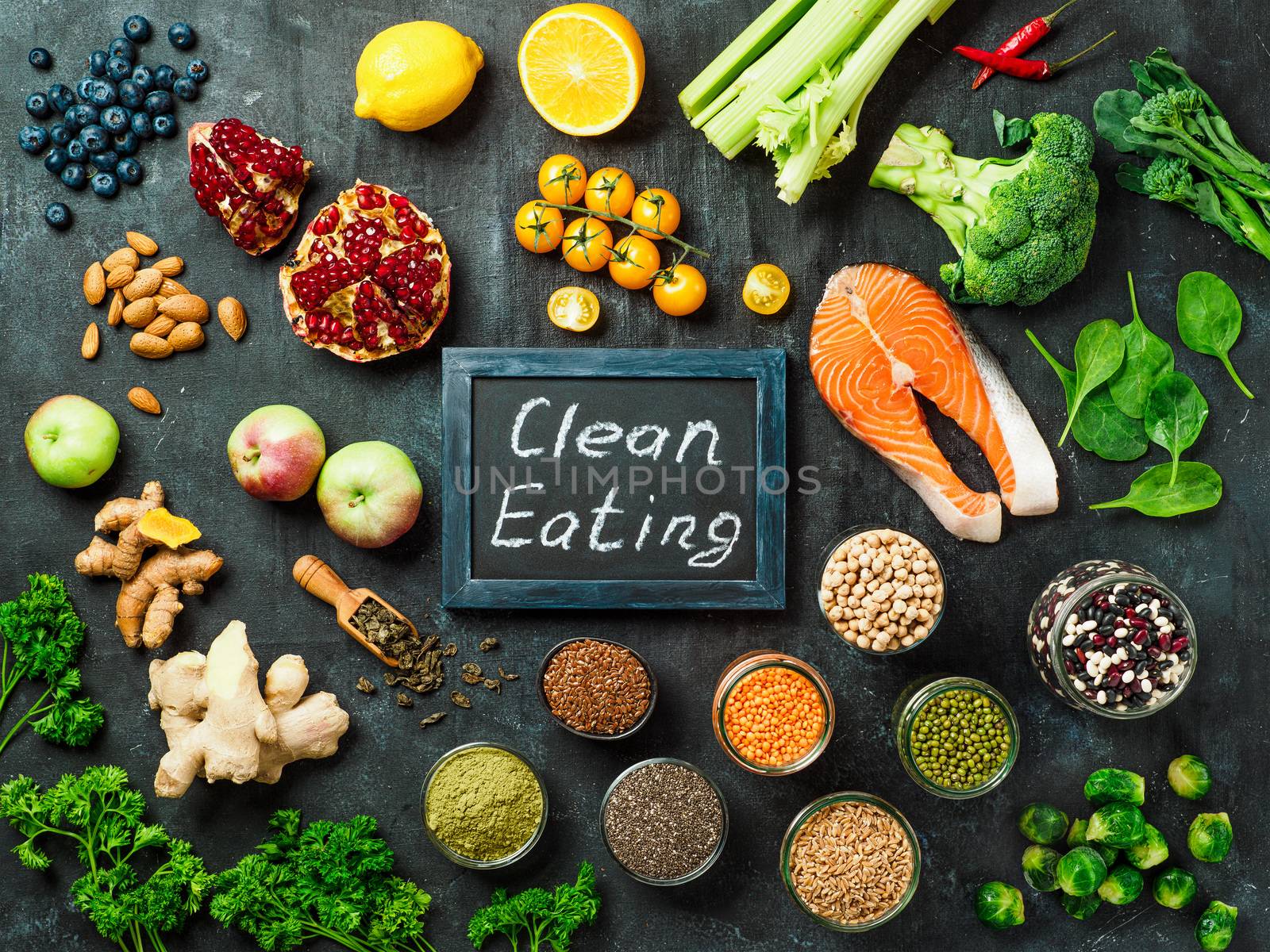 Clean Eating concept. Selection food ingredients and chalkboard with Clean Eating words on dark background. Top view or flat lay.