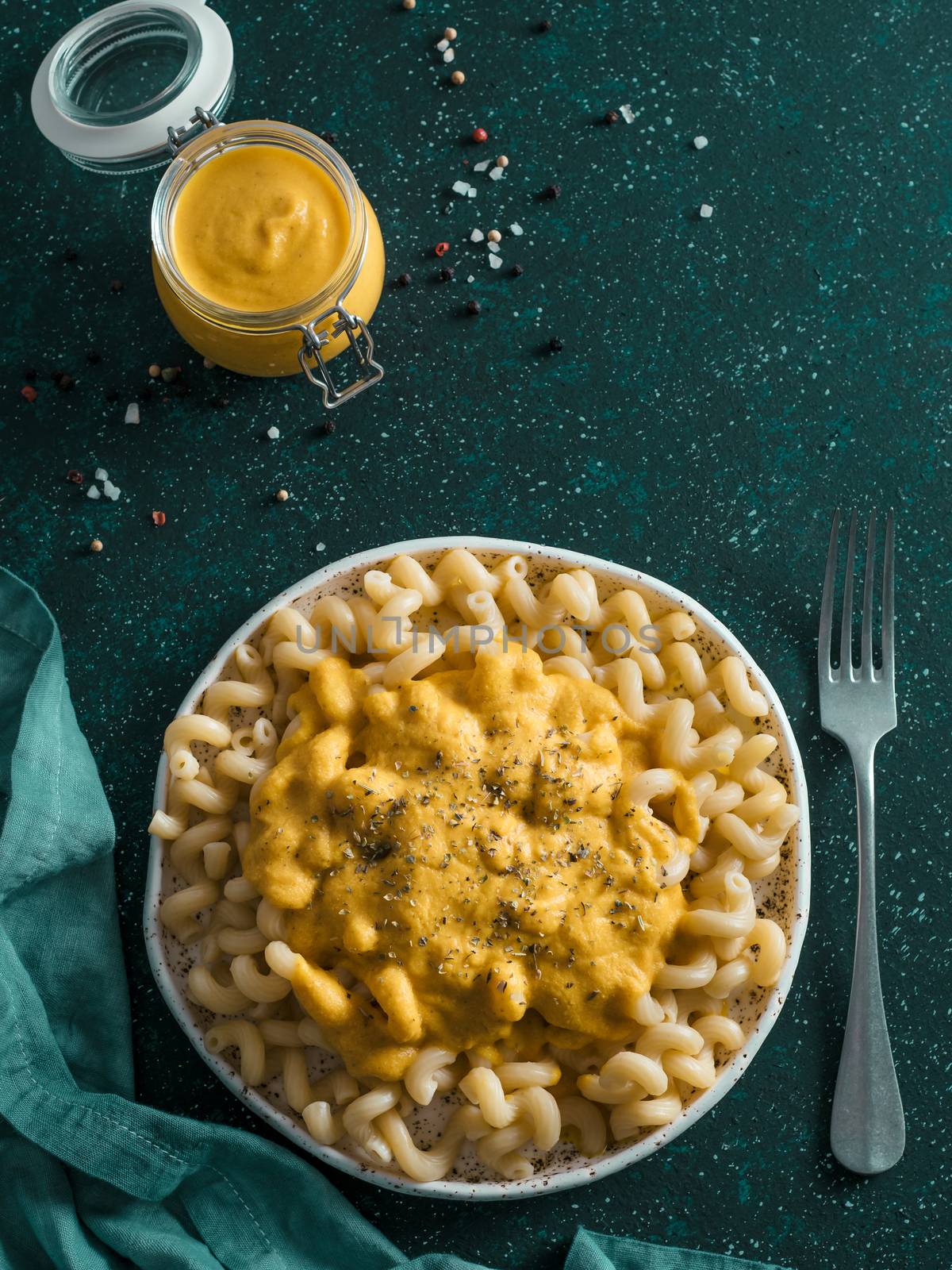 Pasta with vegan creamy chia cheddar sauce on gray background. Ideas and recipe for healthy diet or vegan food. Dish with homemade plant based Chia Cheeze Sauce. Copy space