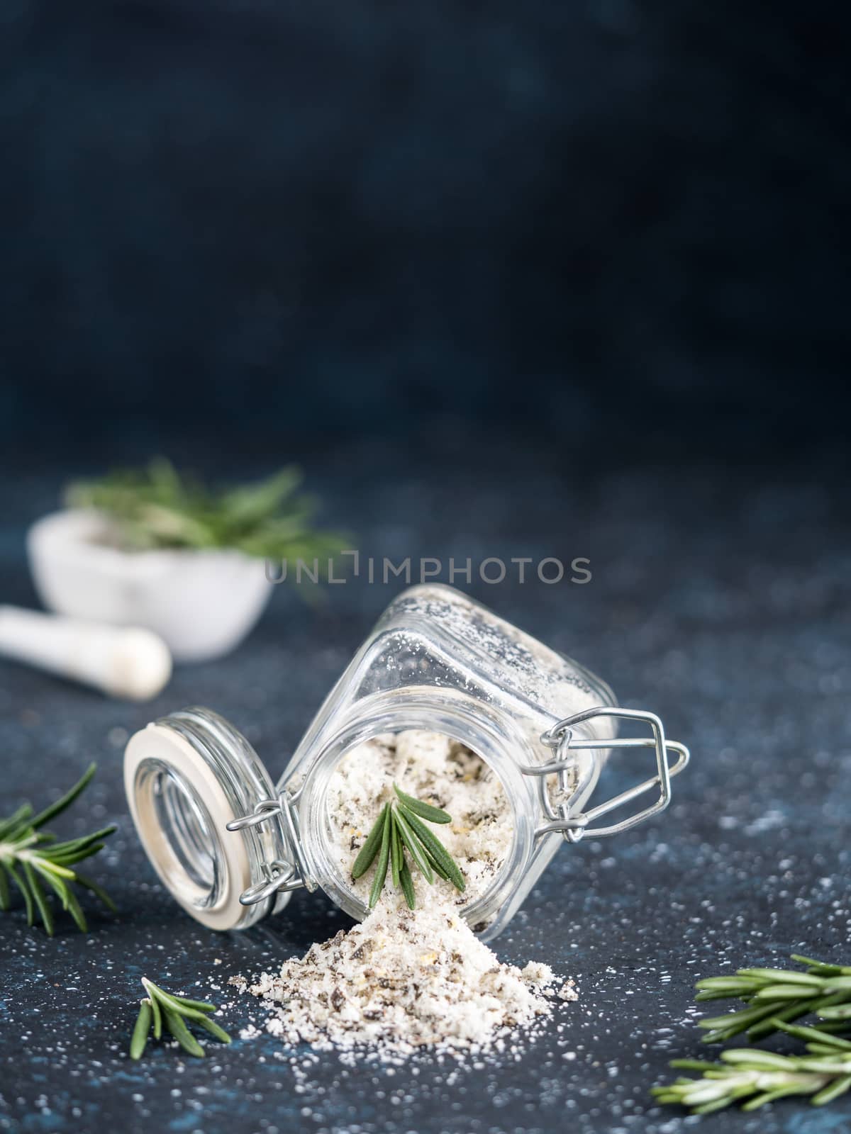 Sea salt scented herb rosemary on dark blue background by fascinadora
