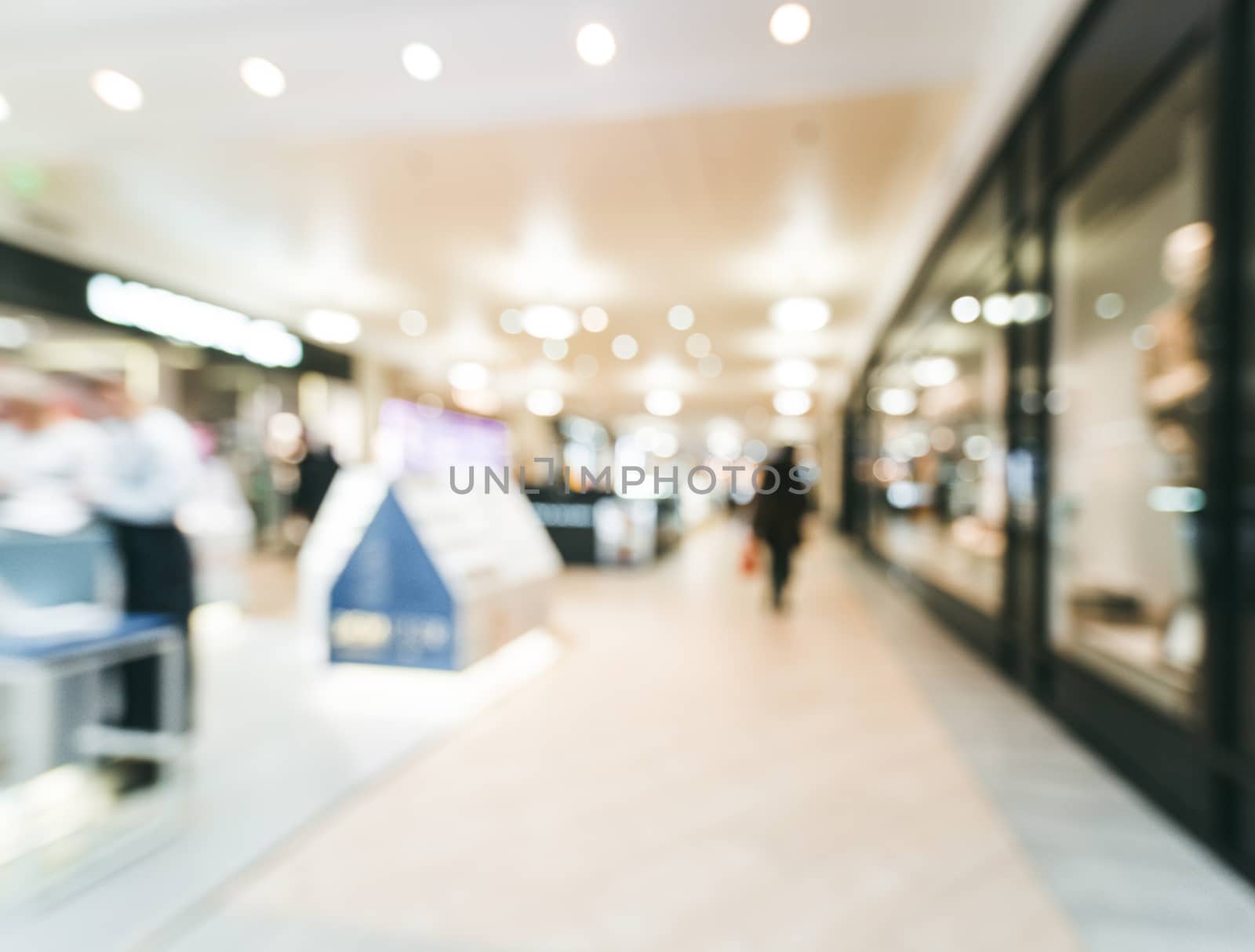 Shopping mall blur background with bokeh. Blurred hall of shopping mall with customers as background. Copy space