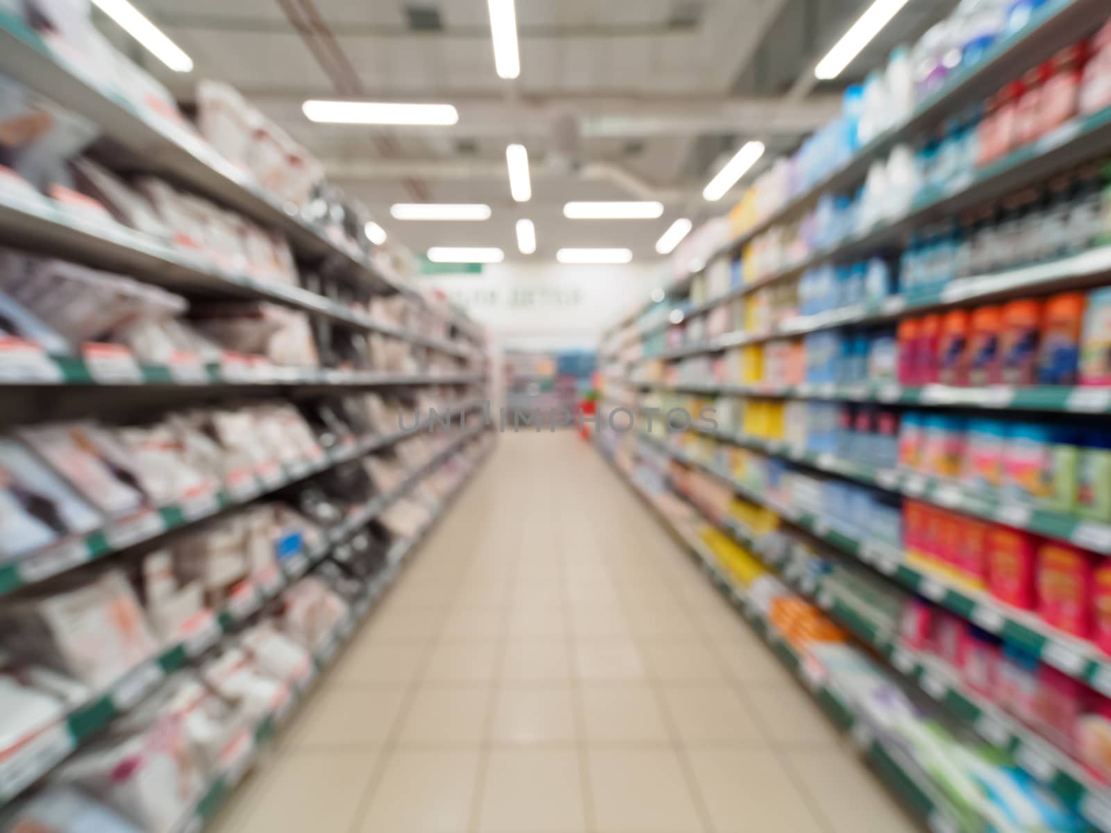 Abstract blurred supermarket aisle with colorful shelves and unrecognizable customers as background