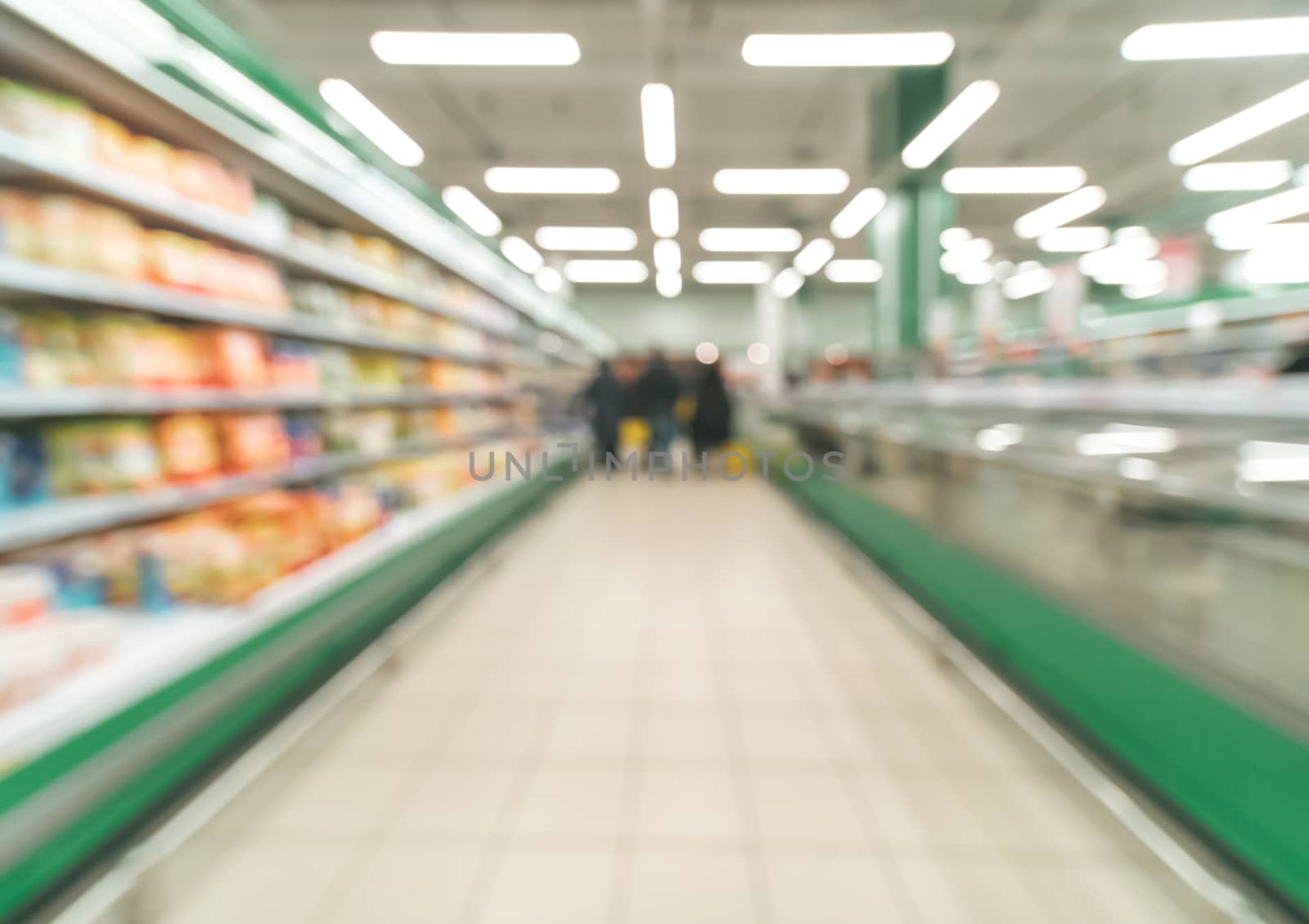 Abstract blurred supermarket aisle with colorful shelves and unrecognizable customers as background