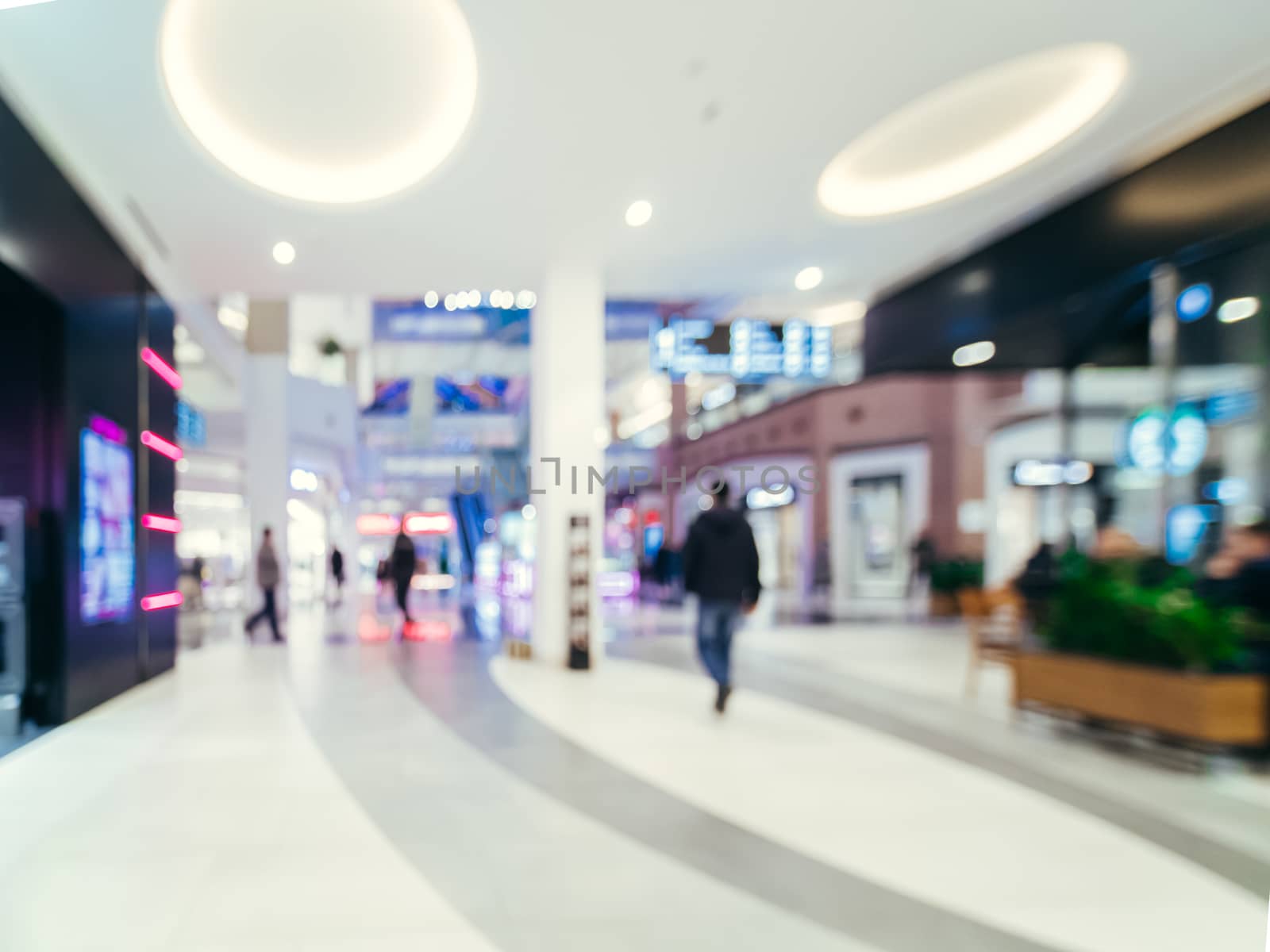 Shopping mall blur background with bokeh. Blurred hall of shopping mall with customers as background. Copy space