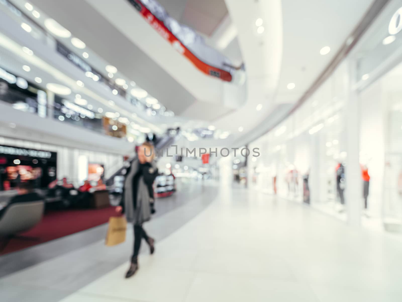 Shopping mall blur background with bokeh. Blurred hall of shopping mall with customers as background. Copy space