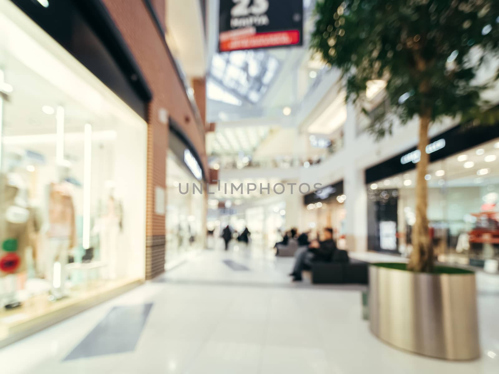 Shopping mall blur background with bokeh. Blurred hall of shopping mall with customers as background. Copy space