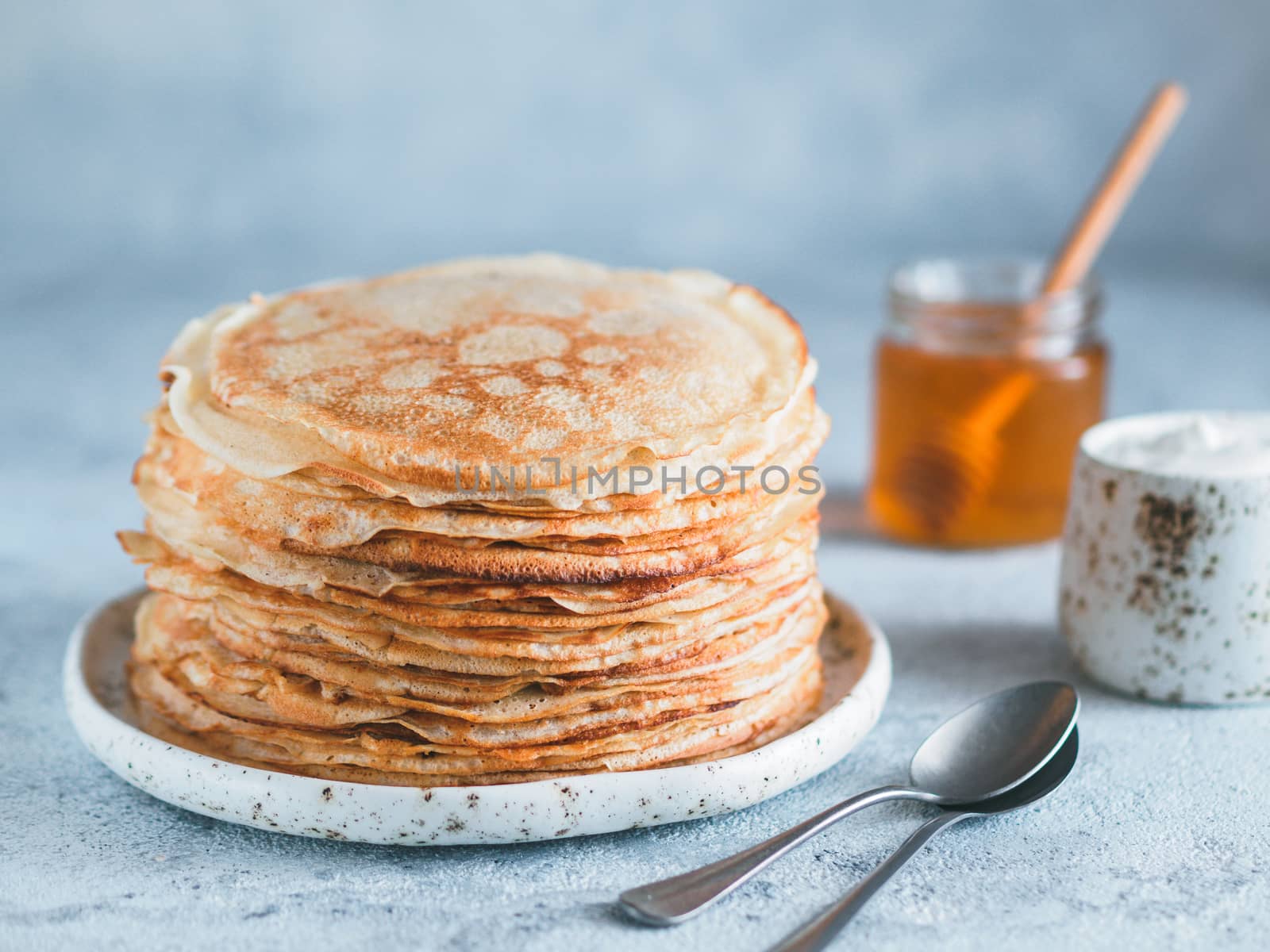 Stack of traditional russian pancakes blini on gray background with copy space. Homemade russian thin pancakes blini. Russian food, russian kitchen