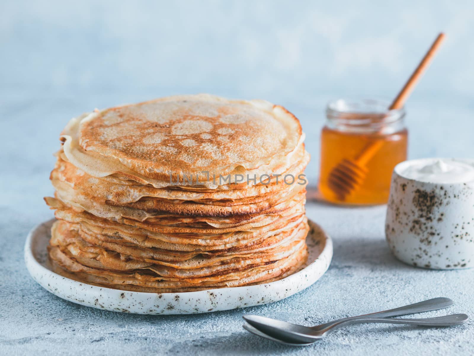 Stack of traditional russian pancakes blini on gray background with copy space. Homemade russian thin pancakes blini. Russian food, russian kitchen