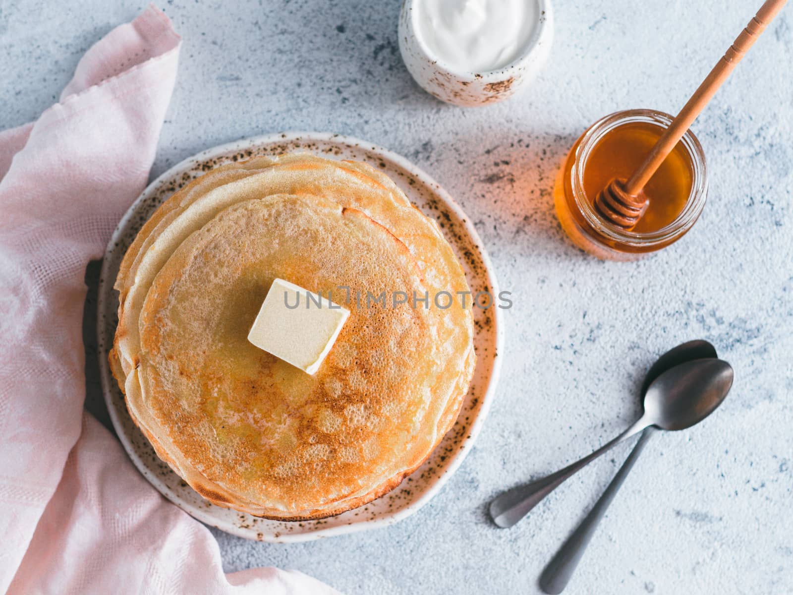 Stack of traditional russian pancakes blini on gray background with copy space. Homemade russian thin pancakes blini. Russian food, russian kitchen. Top view or flat lay