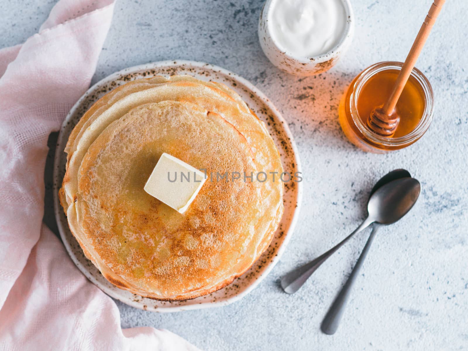 Stack of traditional russian pancakes blini on gray background with copy space. Homemade russian thin pancakes blini. Russian food, russian kitchen. Top view or flat lay
