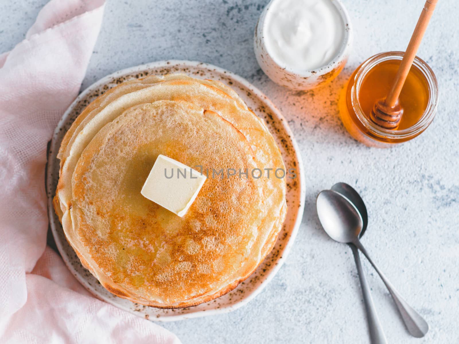 Stack of traditional russian pancakes blini on gray background with copy space. Homemade russian thin pancakes blini. Russian food, russian kitchen. Top view or flat lay