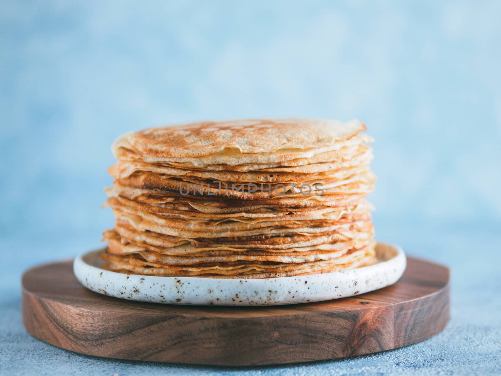 Stack of traditional russian pancakes blini on gray background with copy space. Homemade russian thin pancakes blini. Russian food, russian kitchen