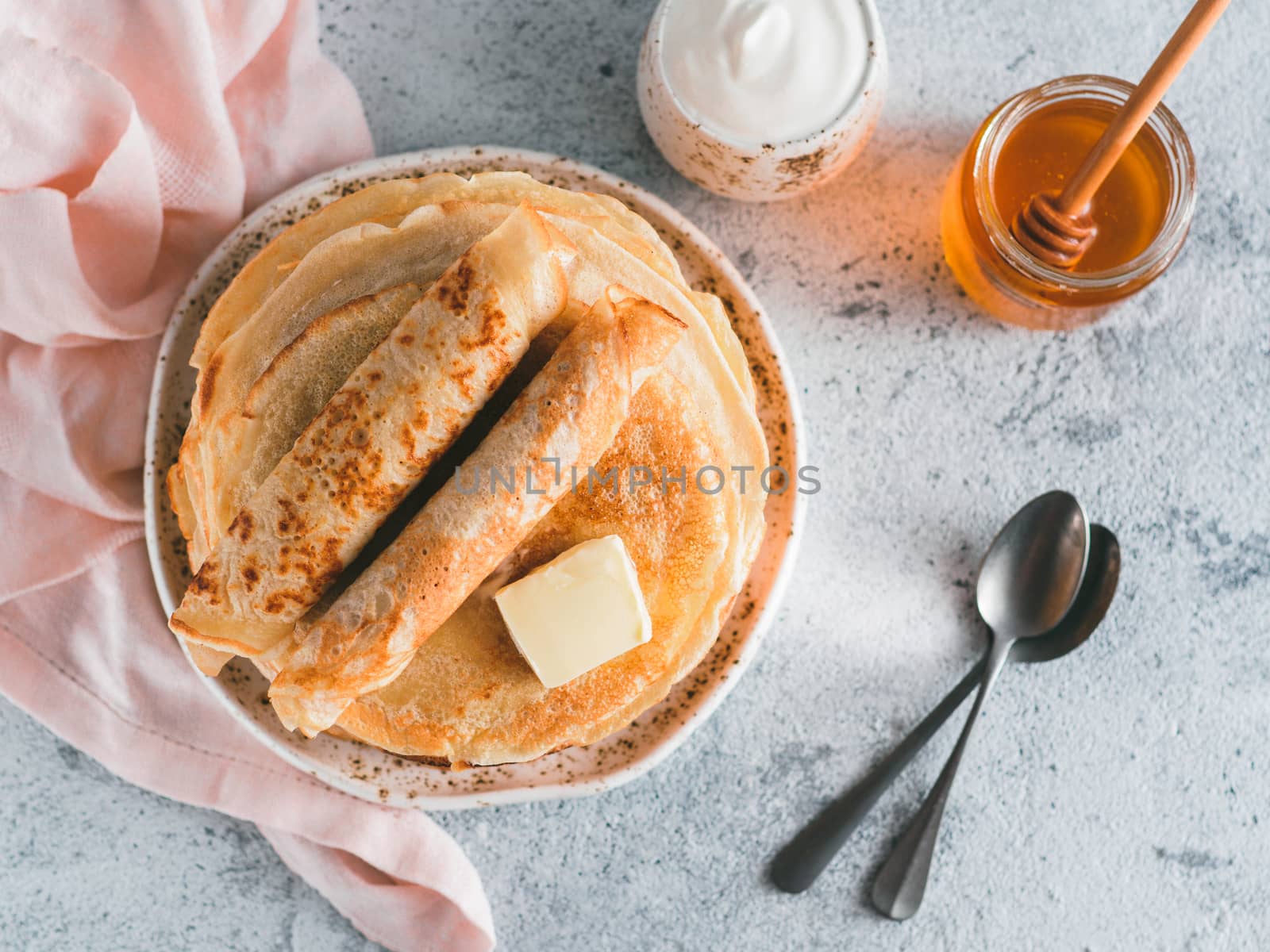 Stack of traditional russian pancakes blini on gray background with copy space. Homemade russian thin pancakes blini. Russian food, russian kitchen. Top view or flat lay