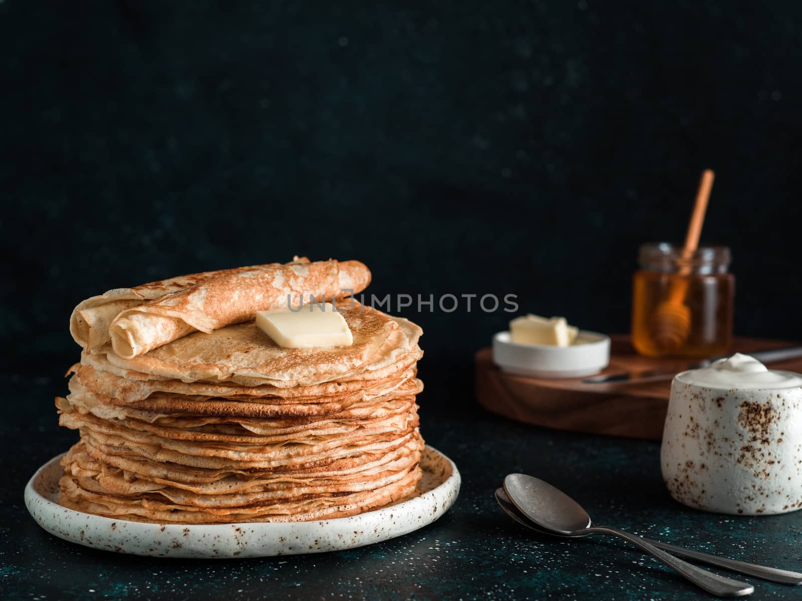 Stack of traditional russian pancakes blini on black background with copy space. Homemade russian thin pancakes blini. Russian food, russian kitchen