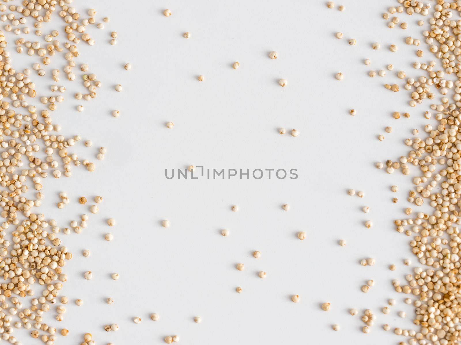 Grain of real quinoa isolated on white background. Uncooked raw quinoa as background. Healthy vegan food concept and pattern. Copy space. Top view or flat lay.