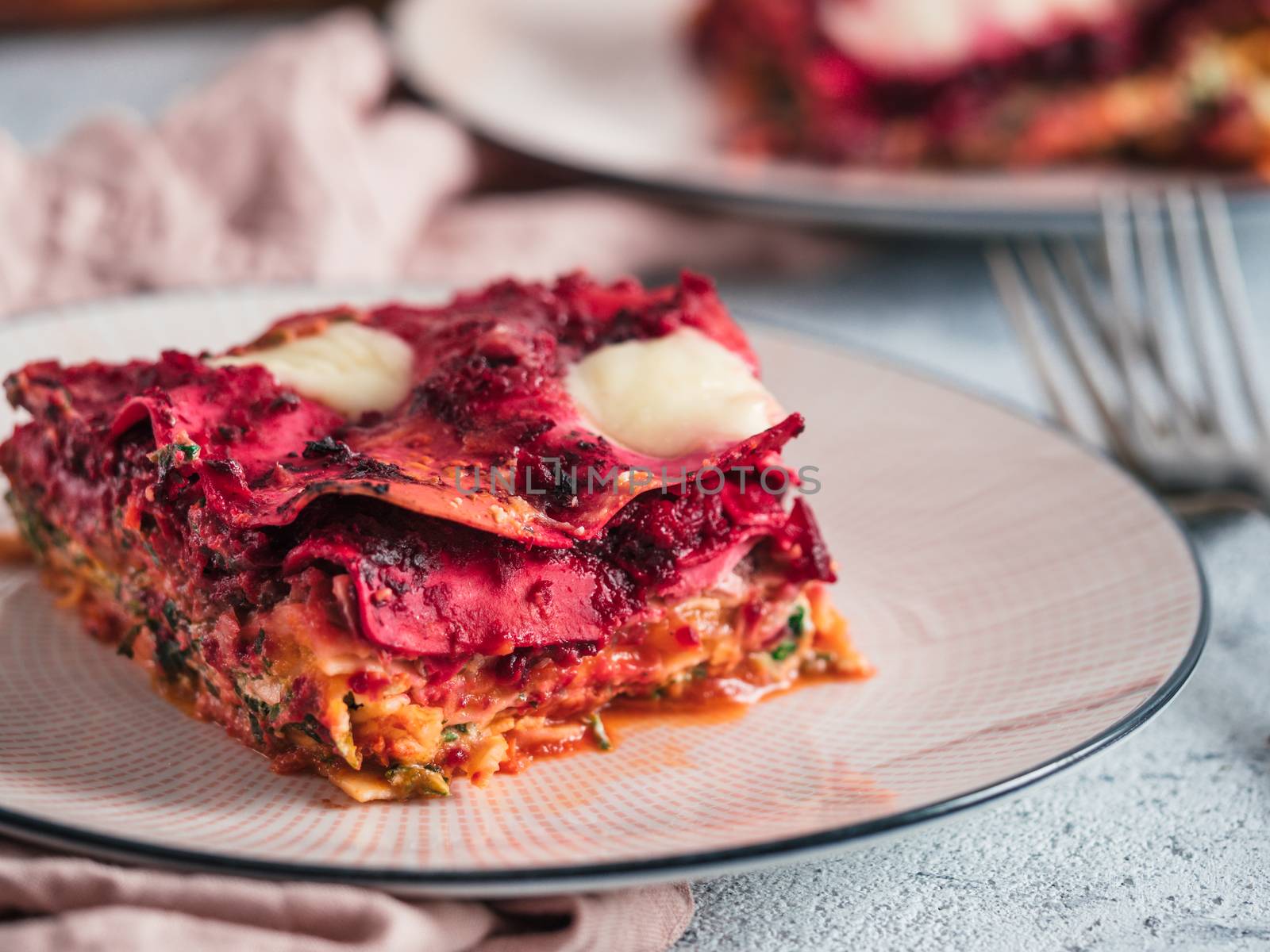 Vegetable Packed Rainbow Lasagne on pink plate. Ideas and recipes for healthy vegetarian dinner or lunch. Lasagne with beetroot, pumpkin, mushrooms, ricotta, spinach, mozarella