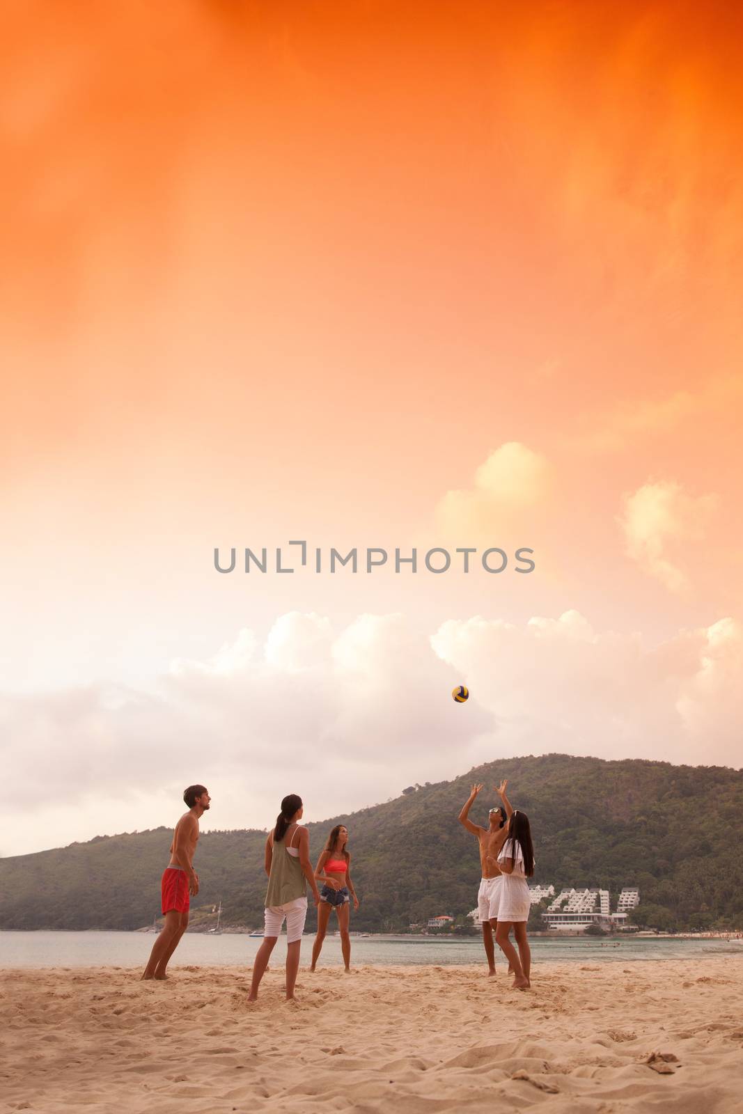 Group of young people playing volleyball at beach