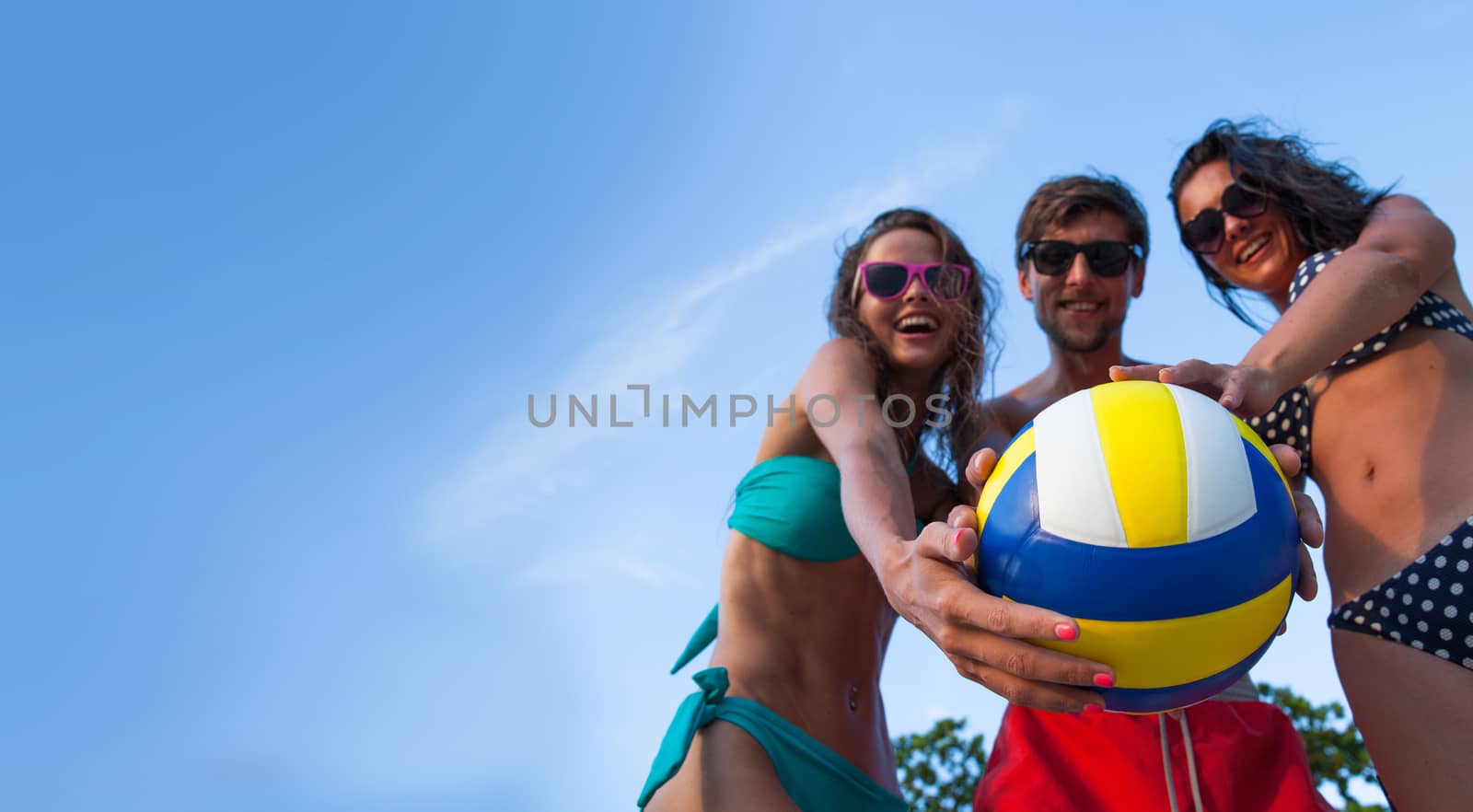 Group of young people playing volleyball outdoors