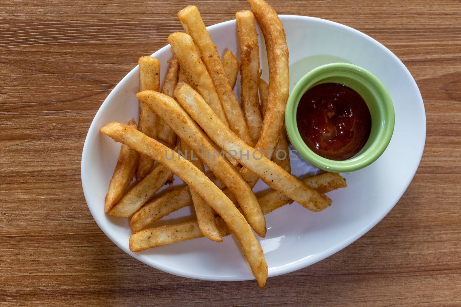 French fries and ketchup on plate, shot from above