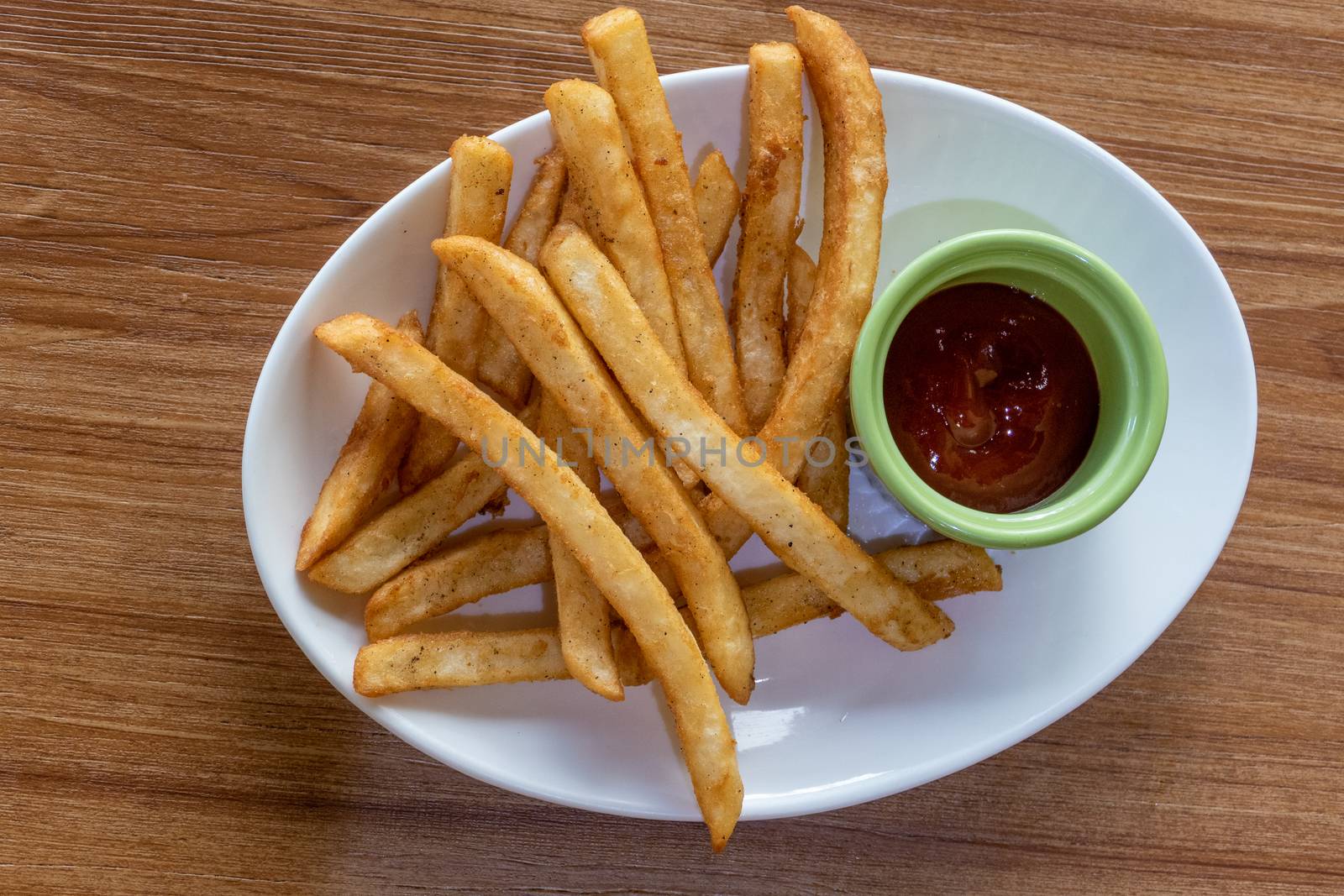 French fries and ketchup on plate, shot from above