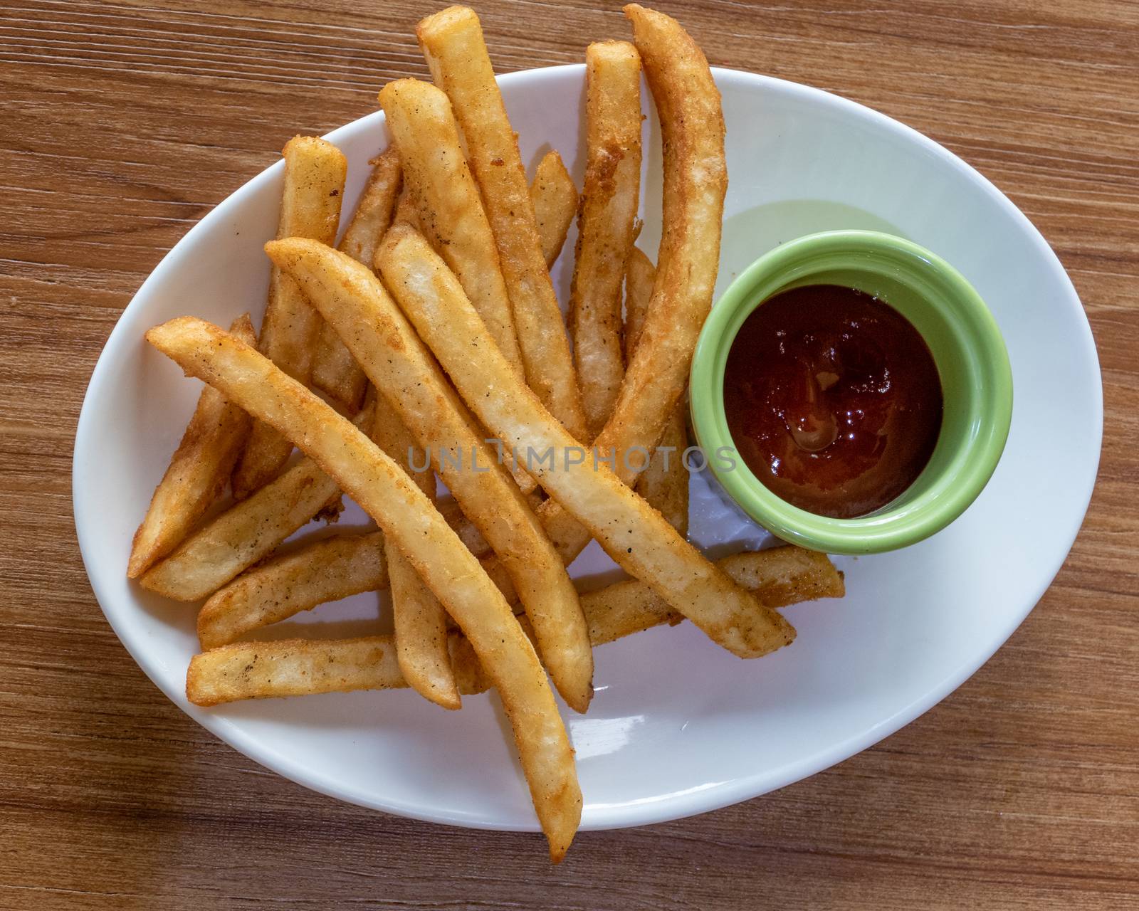 French fries and ketchup on plate, shot from above