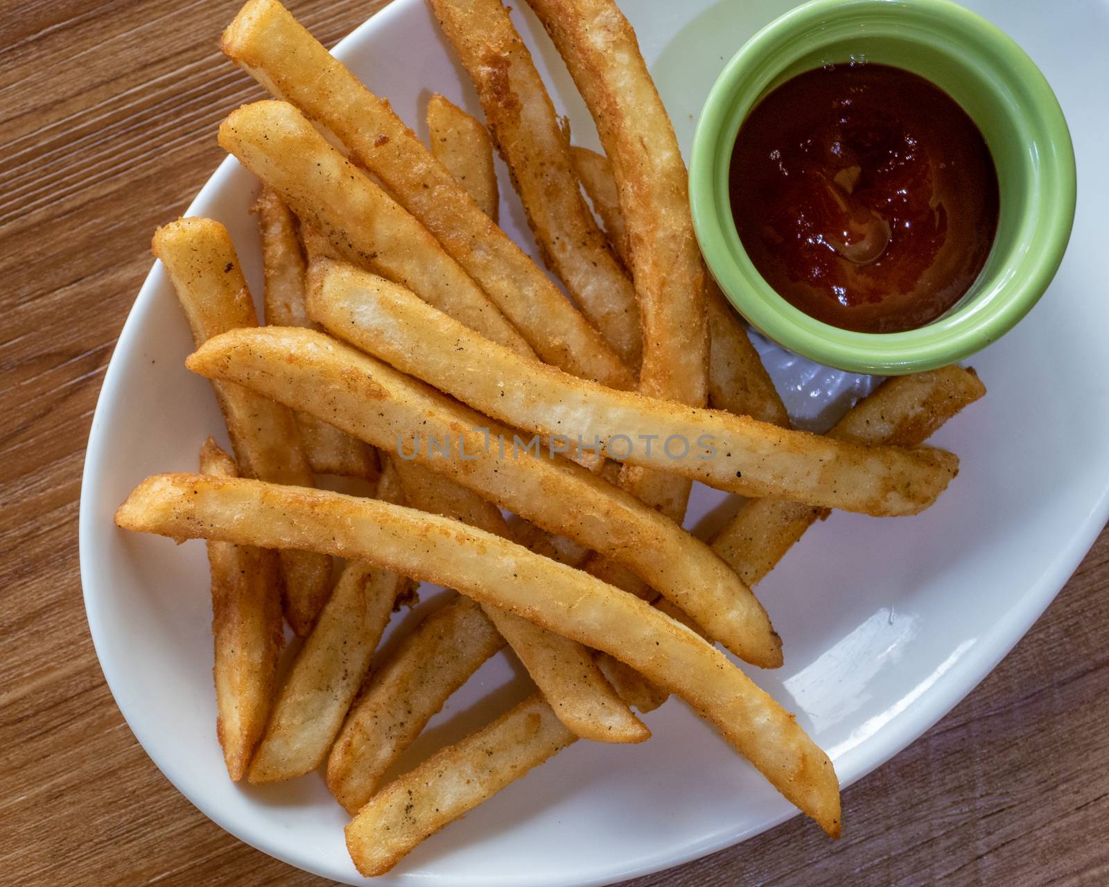 French fries and ketchup on plate, shot from above