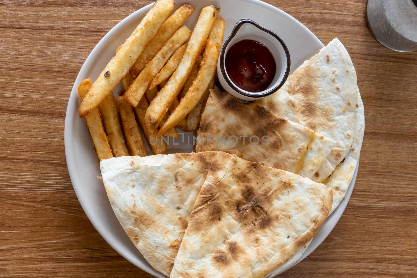 Quesadilla and french fries on plate, shot from above